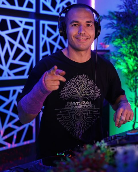 Example: a DJ behind the decks, from the chest up, with the face clearly visible